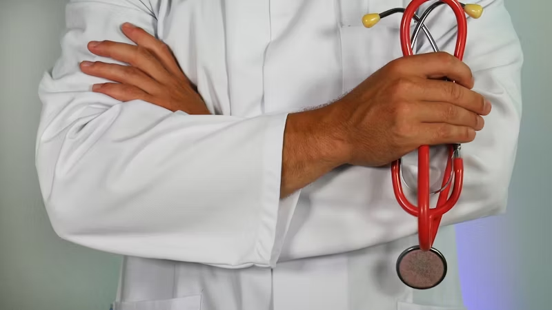 doctor with hands crossed holding a stethoscope 