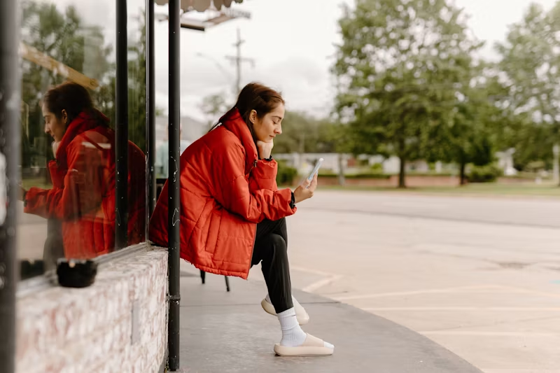 woman sitting and looking at her phone