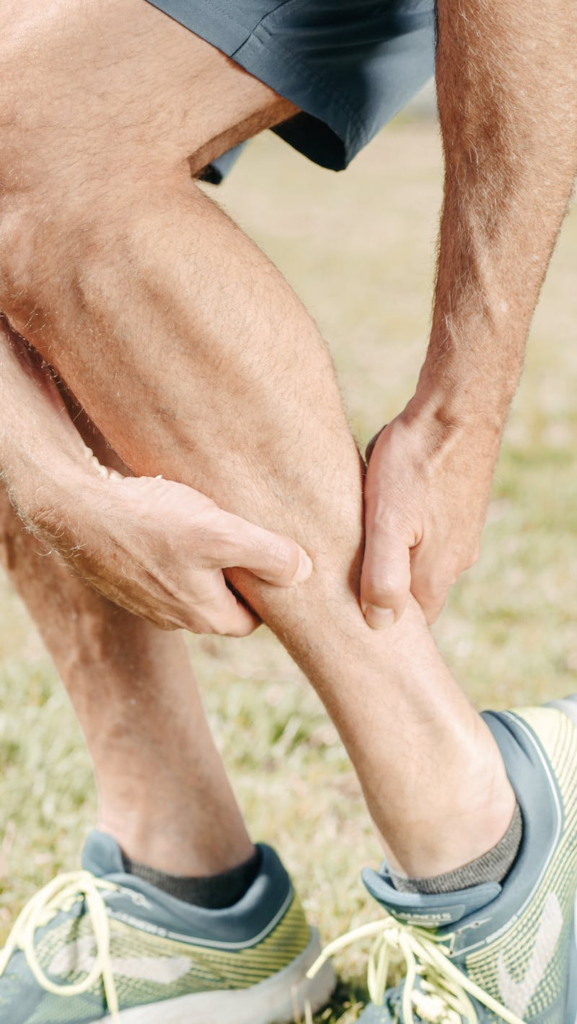 man holding his cramping leg