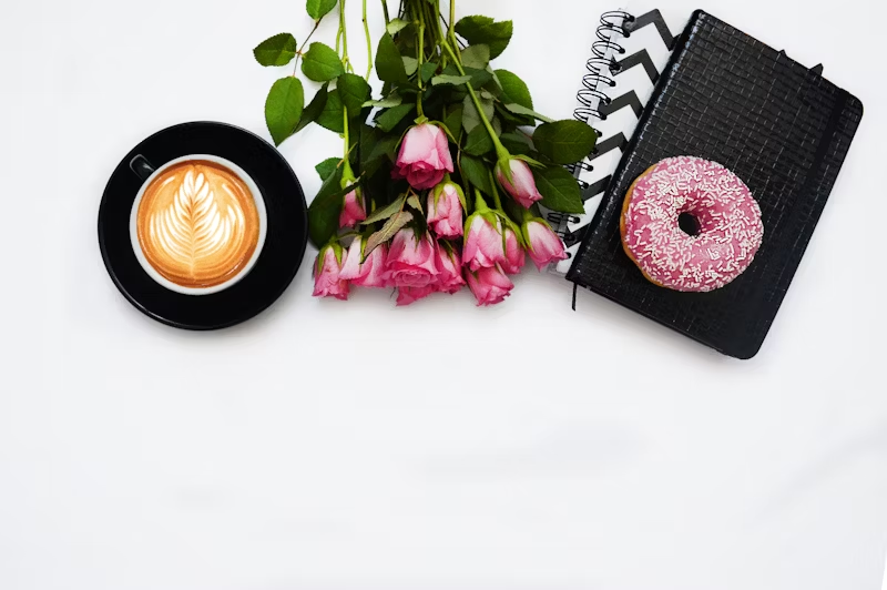 fancy coffee and doughnut with a bouquet of flowers