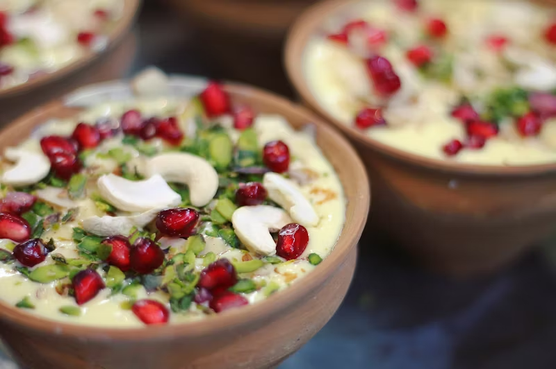 hummus with cashews, onion, and pomegranate seeds on top