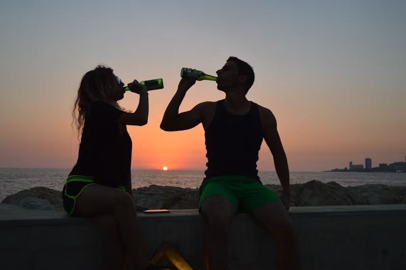 drinking beers on the beach at sunset