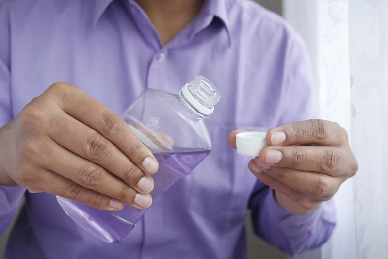 man pouring mouthwash