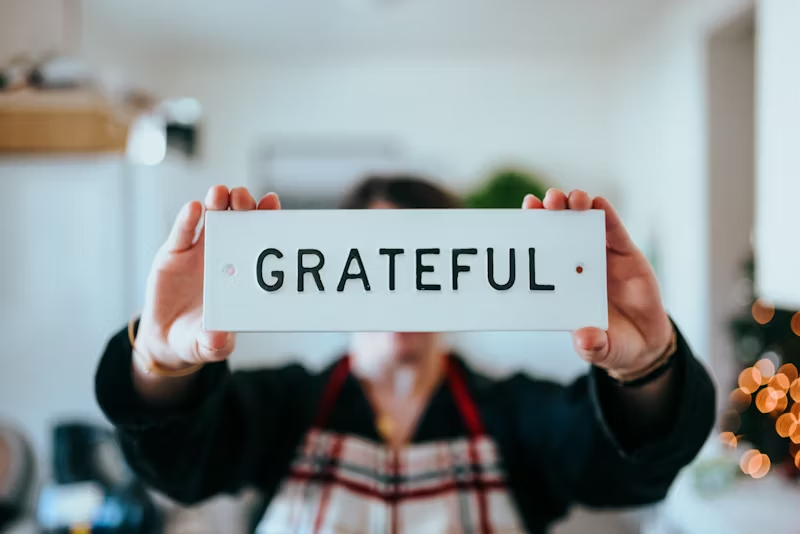 person holding a sign that says GRATEFUL