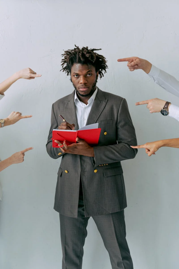 man in a suit with many hands pointed at him