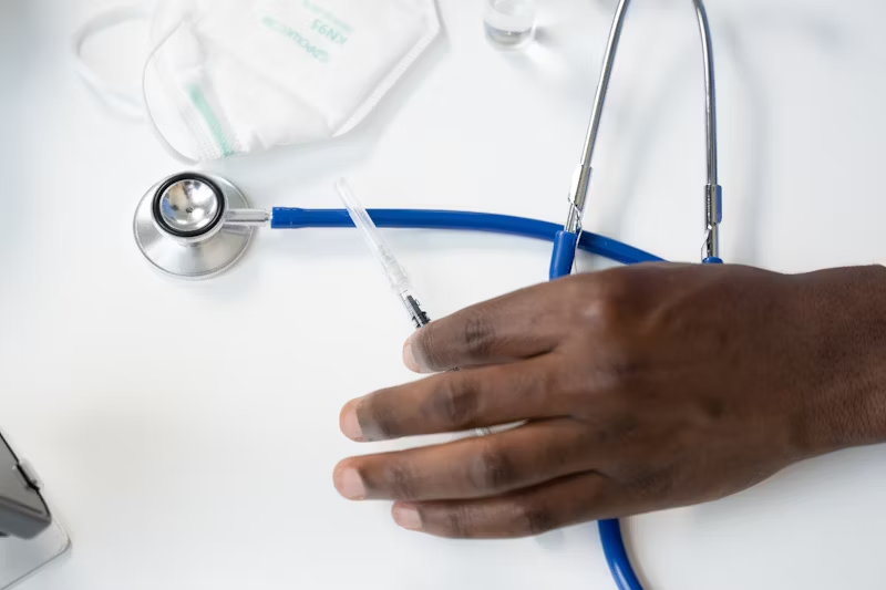 a doctors hand picking up a syringe