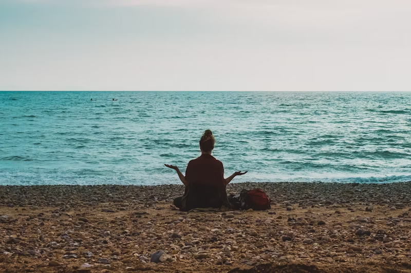 woman meditating beach
