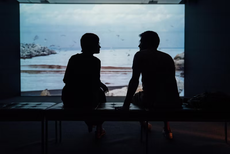 two people having a conversation in front of a screen