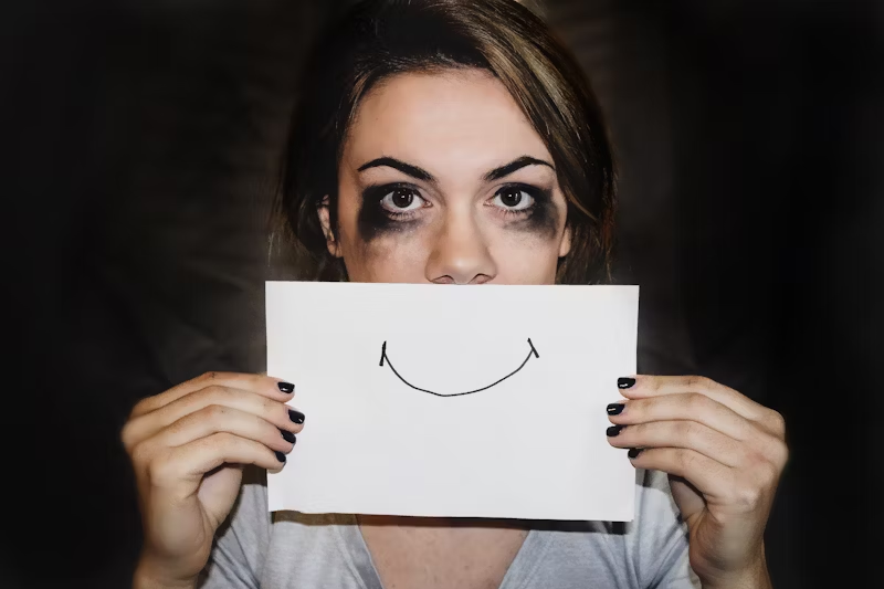 a woman crying with a smiley face over her mouth