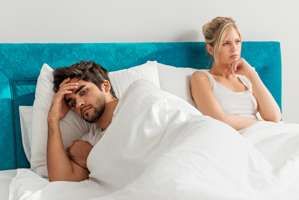 Young couple on the bed; problems in the bedroom
