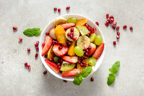Fresh fruit salad on bright background, healthy diet concept