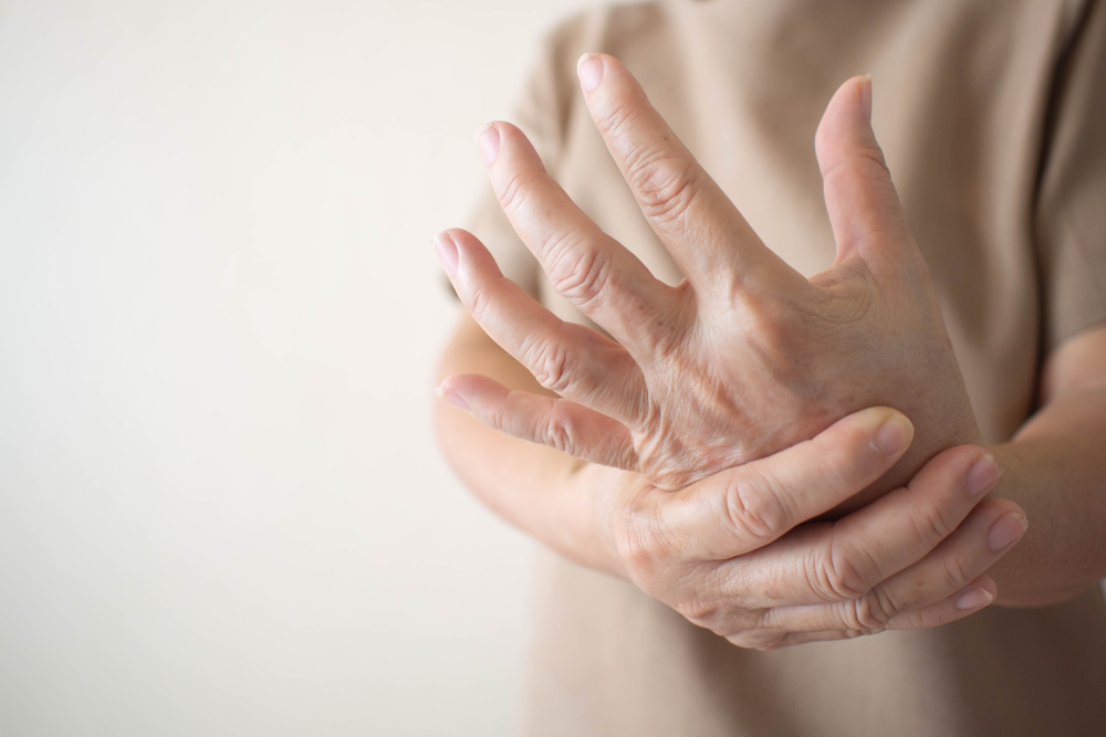 Elderly woman suffering from pain, numbness or weakness in hands. Causes of hurt include osteoarthritis, rheumatoid arthritis, gout, peripheral neuropathy, lupus or Raynaud’s phenomenon. Health care.
