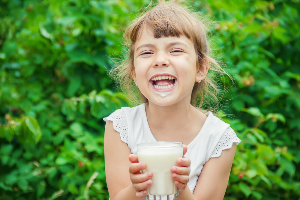 The child drinks milk. Selective focus.