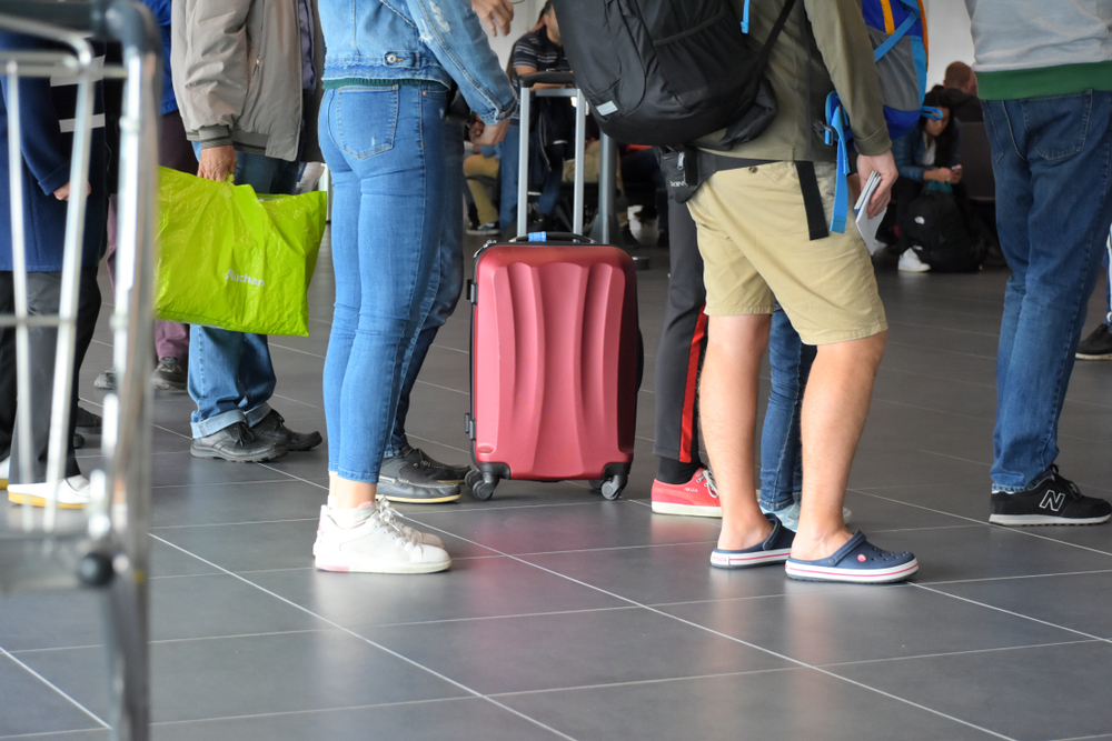 Airport passengers queue with hand luggages waiting boarding at the terminal. Budapest, Hungary - 29 september 2018