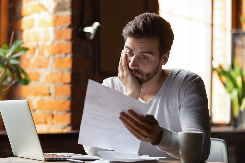 Confused frustrated young man reading letter in cafe, debt notification, bad financial report, money problem, money problem, upset student receiving bad news, unsuccessful exam or test results
