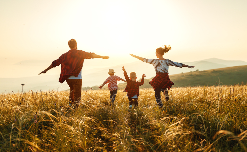 Happy family: mother, father, children son and daughter on nature on sunset