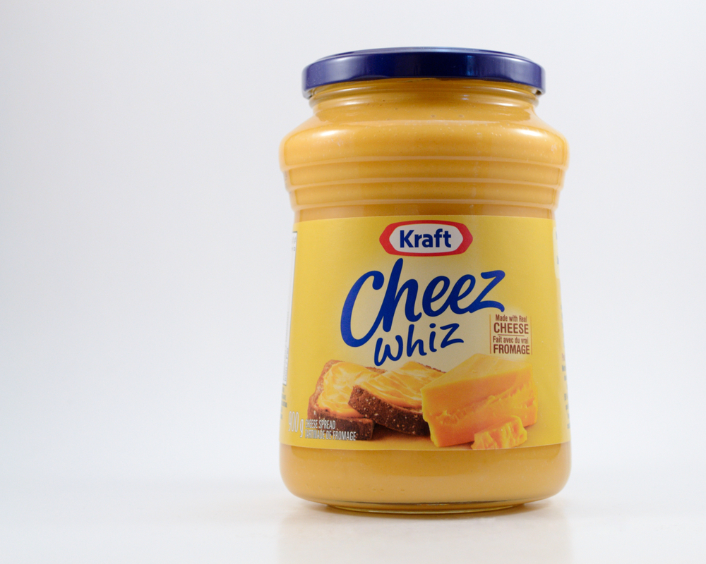 Winnipeg, Manitoba - November 14, 2019: Jar of Kraft Cheez Whiz on a white background with copy space. Kraft began his career by selling cheese from a horse-drawn wagon in 1903 in Canada.
