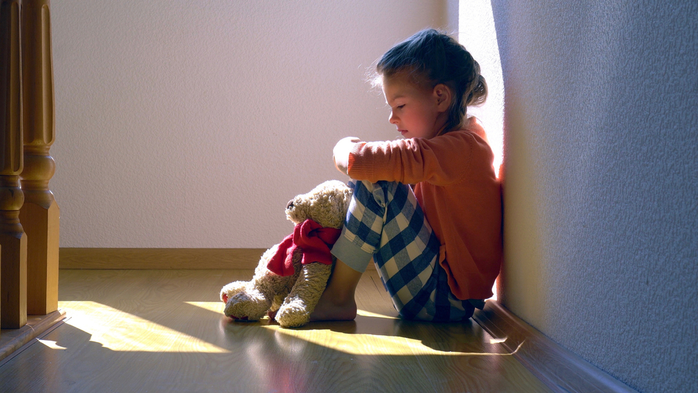 Little girl on the floor sad.