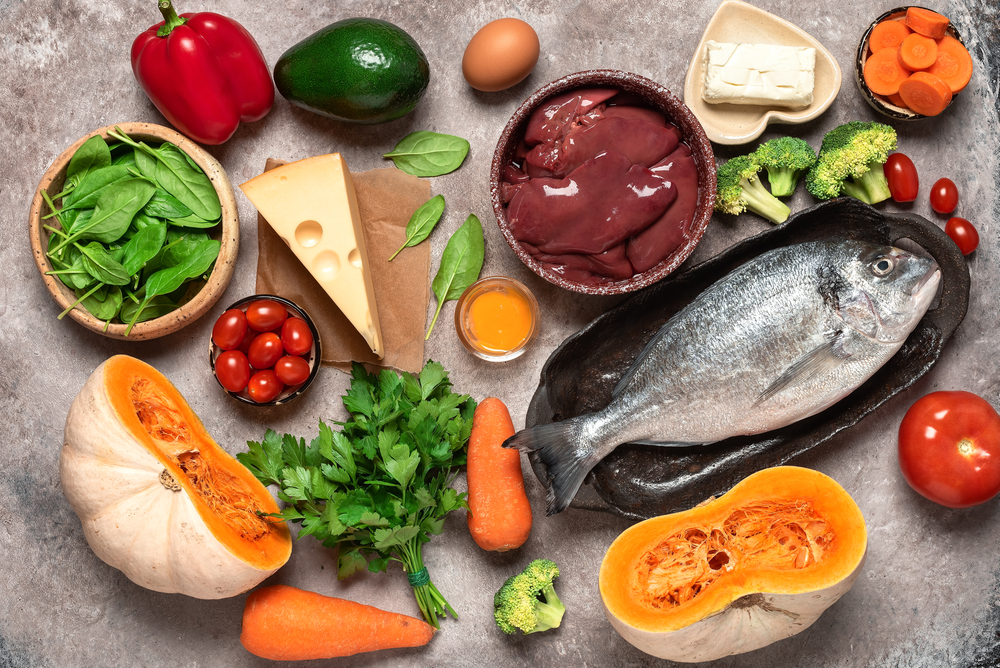 Healthy balanced food background. Foods rich in vitamin A. Turkey liver, vegetables, fresh fish, butter and cheese. Top view, flat lay

