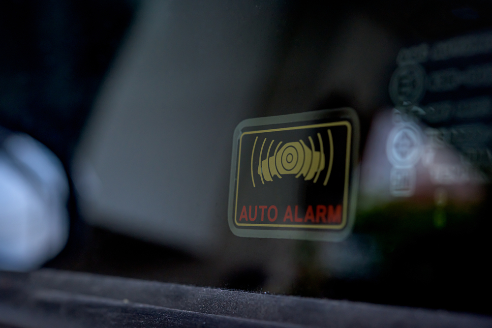 Close up shot of car auto alarm system symbol sticker indicate the active stolen car emergency alarm security system on the side-facing window on a vehicle