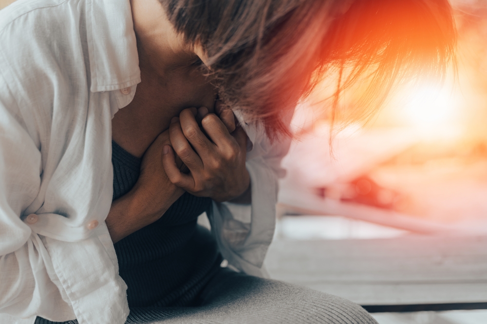 Woman's hand on chest with red spot as suffering on chest pain. Female suffer from heart attack,Lung Problems,Myocarditis, heart burn,Pneumonia or lung abscess, pulmonary embolism day

