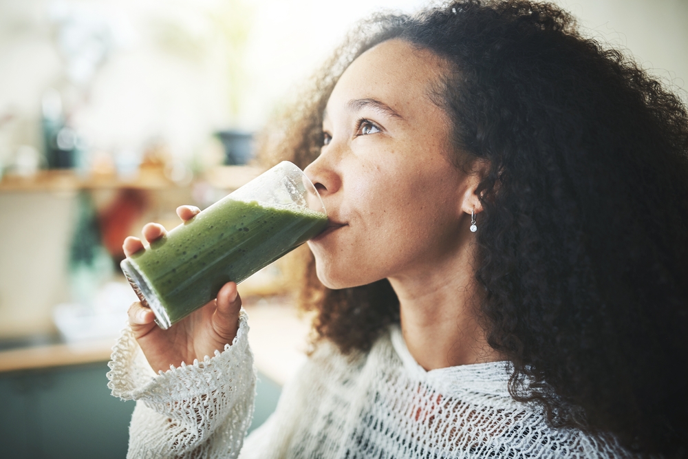 African girl enjoying a green smoothie