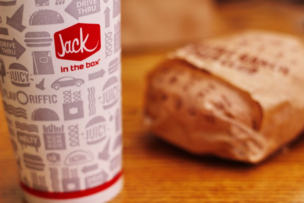 WASHINGTON, USA - JULY 29 2022 : A home-style rance chiken club burger on a wooden table with soft drinks in a jack in the box restaurant in the USA.

