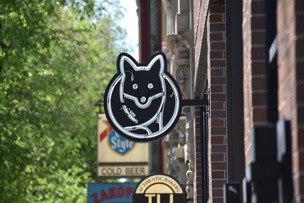 Chicago, IL, USA - 05-21-2023: Fox Trot store sign hanging on the side of brick building in Wicker Park, Chicago.