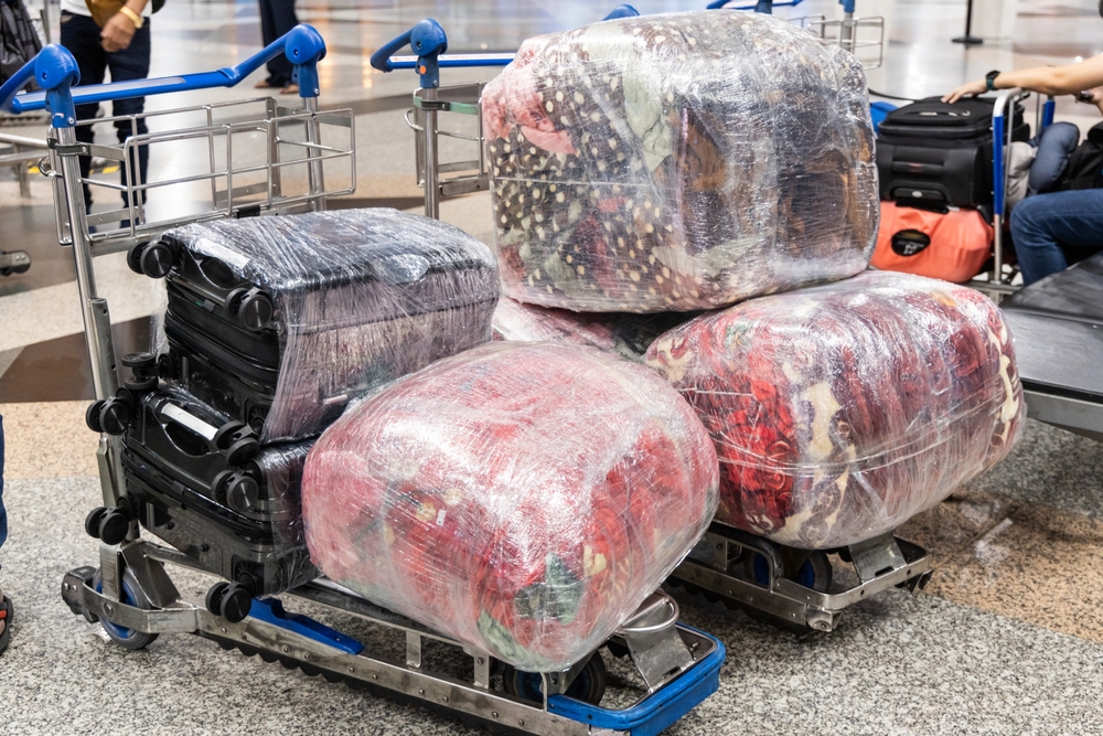 Multiple luggages wrapped with protective film for protection and security during transportation in air travel.