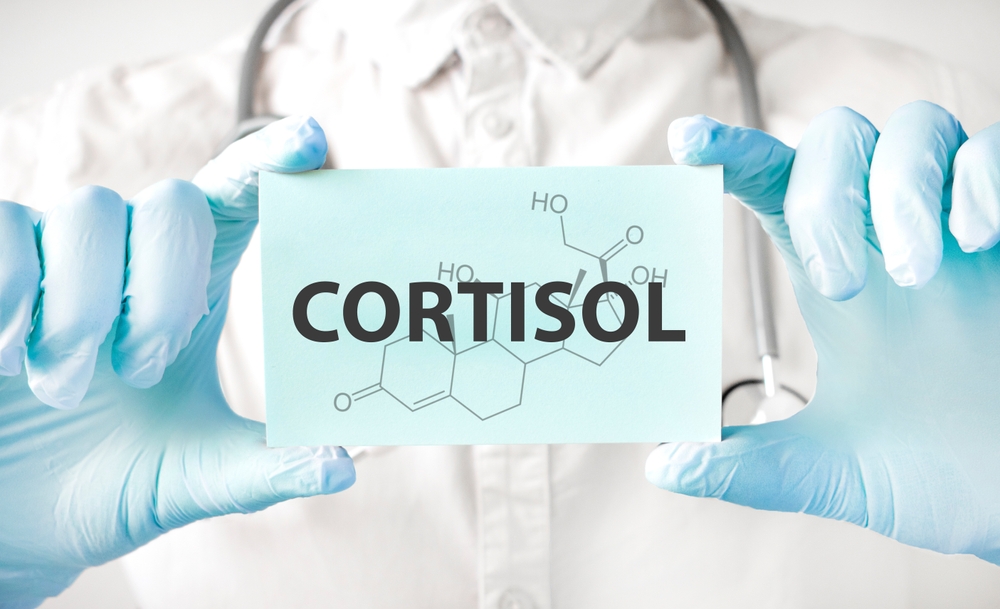 Doctor holding card in hands and pointing the word CORTISOL