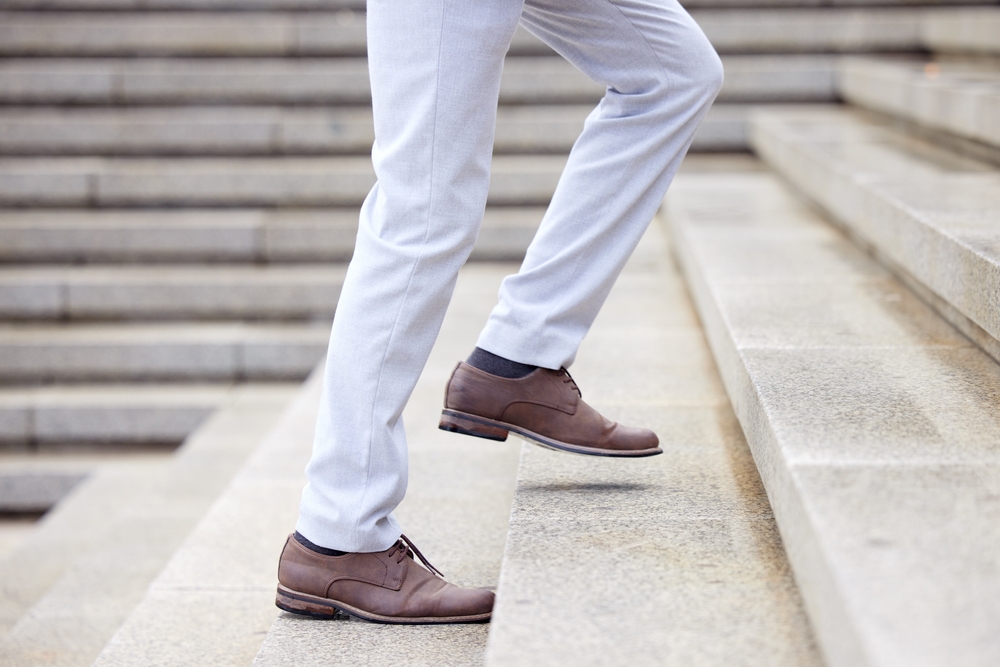 Businessman, stairs and success taking steps toward progress, development and achievement for industry. Entrepreneur, walking and climbing up the corporate ladder, financial and career growth for job
