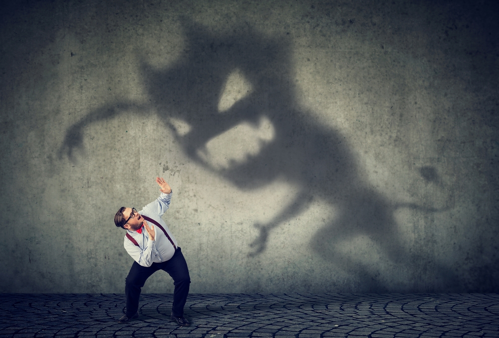 Business man scared by his monster shadow