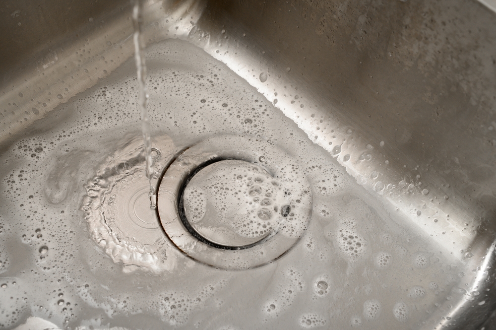 Water consumption, close-up tap with water flowing into the drain