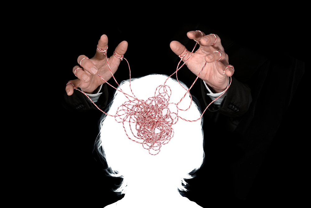 Obeying master hand pulling the strings in the silhouette of a human head. Concept of mental health, emotional manipulation, world conspiracy theories., control and dictatorship