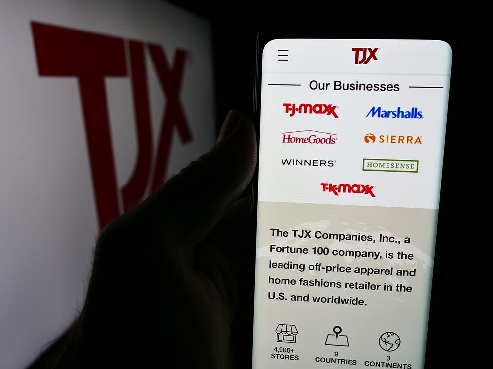 Stuttgart, Germany - 08-13-2024: Person holding cellphone with webpage of US department store company The TJX Companies Inc. in front of logo. Focus on center of phone display. Unmodified photo.
