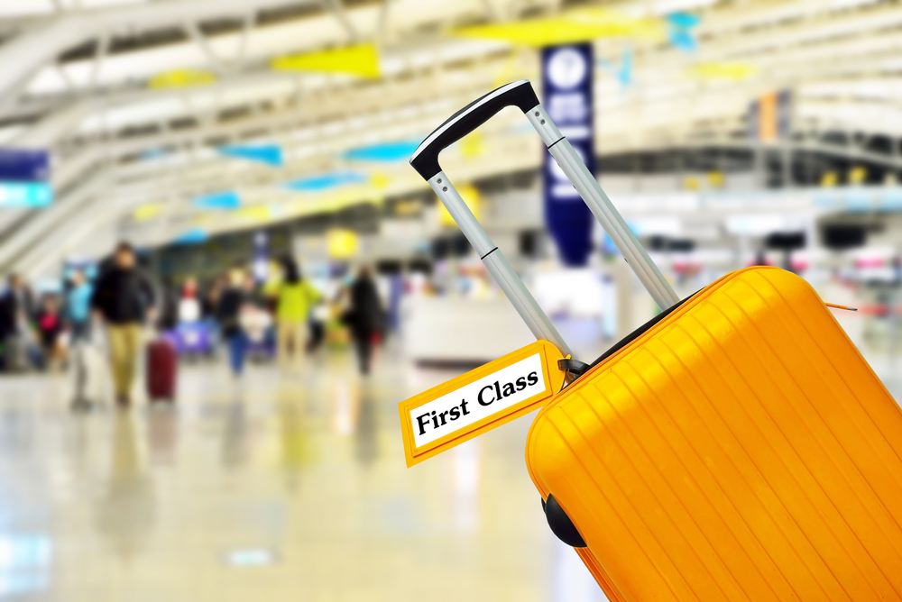 First Class. Suitcase with label at airport.