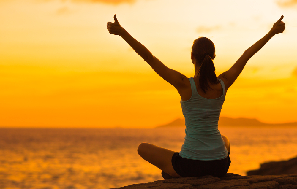 Healthy woman celebrating during a beautiful sunset. Happy and Free.