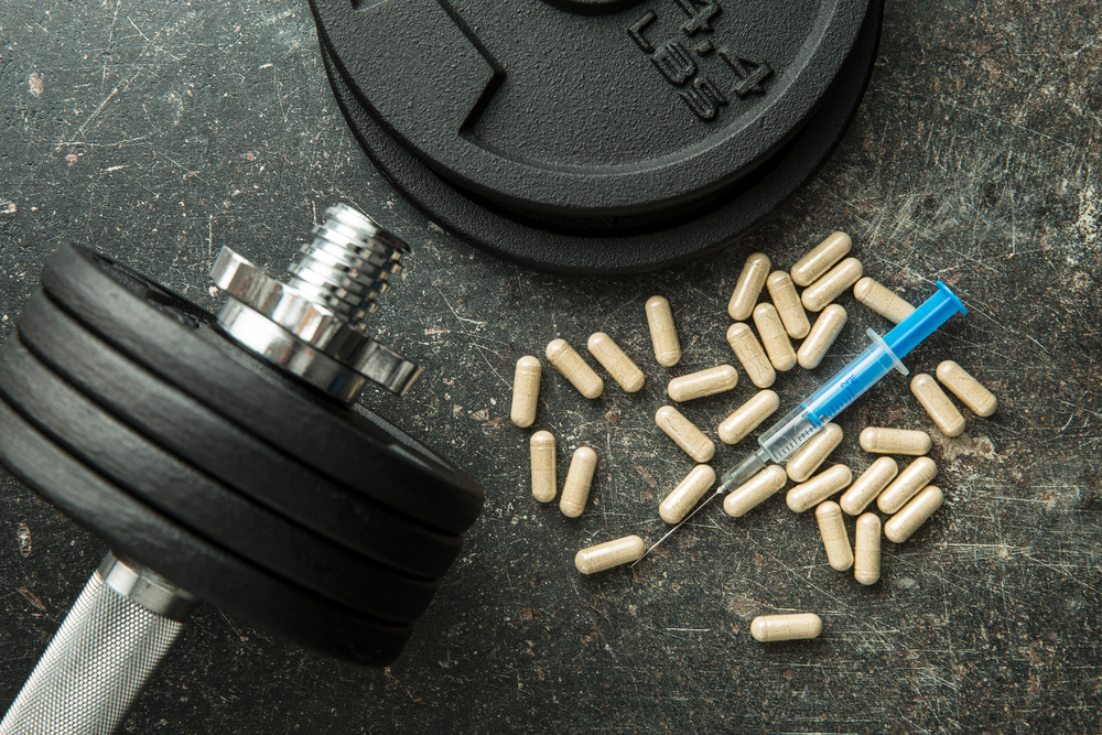 Doping in sport. Syringe and dumbbell.