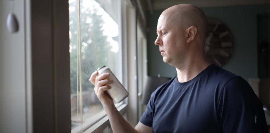 Evan looks at a can of alcohol