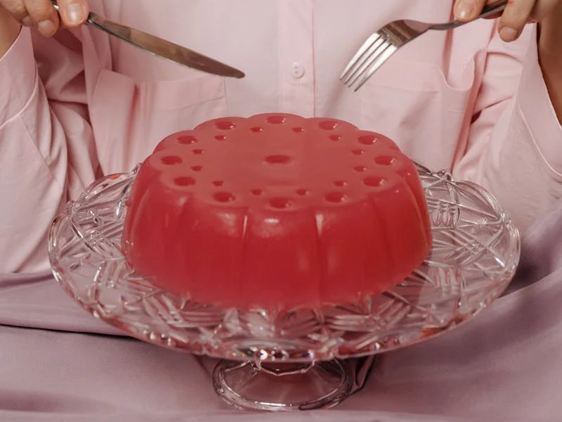 a person about to cut into some gelatin