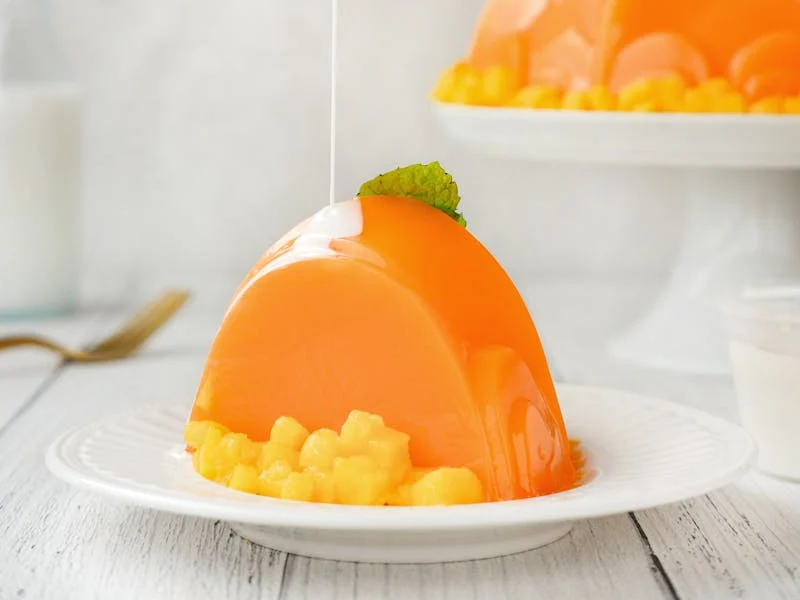 orange gelatin with a white sauce poured on top
