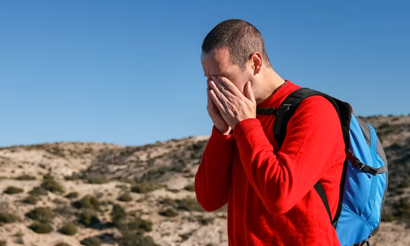 a man with a headache outside