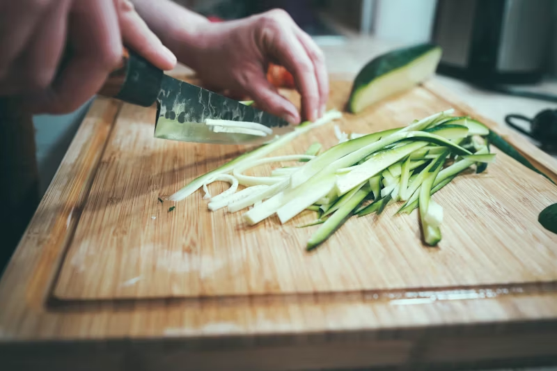 a zucchini being sliced up thinly