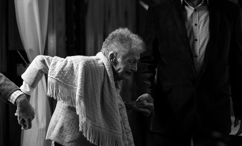 an older woman being helped to walk