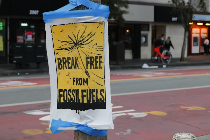 poster on a telephone pole warning against fossil fuels
