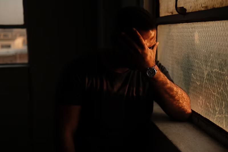 a person sitting in a shadowy corner