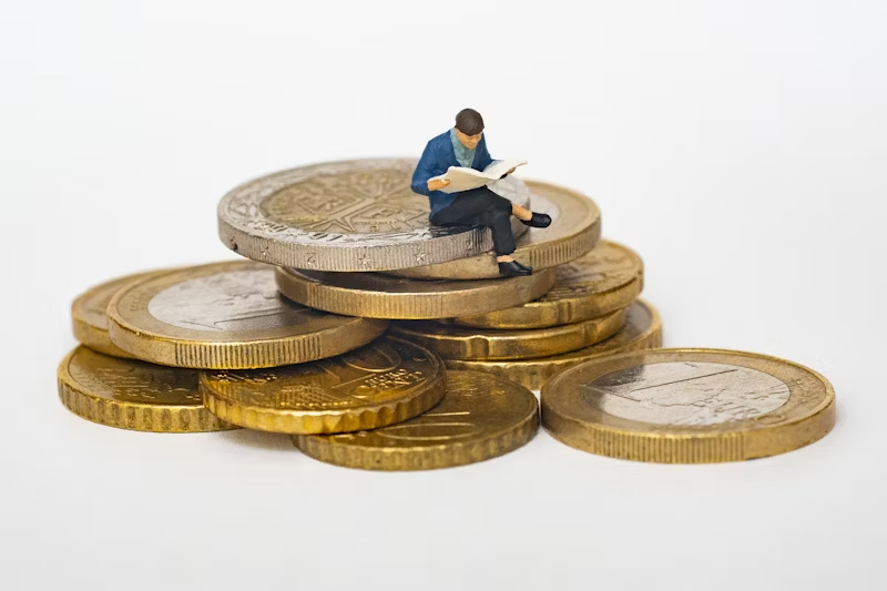 small man sitting on coins
