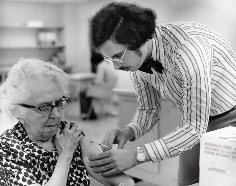 black and white photo of a woman receiving a vaccine
