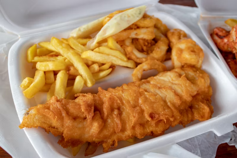 a to-go container of fish and chips
