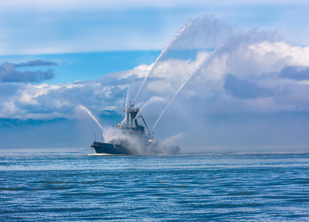 fire hose boat spraying water on Kamchatka on Paciic ocean
